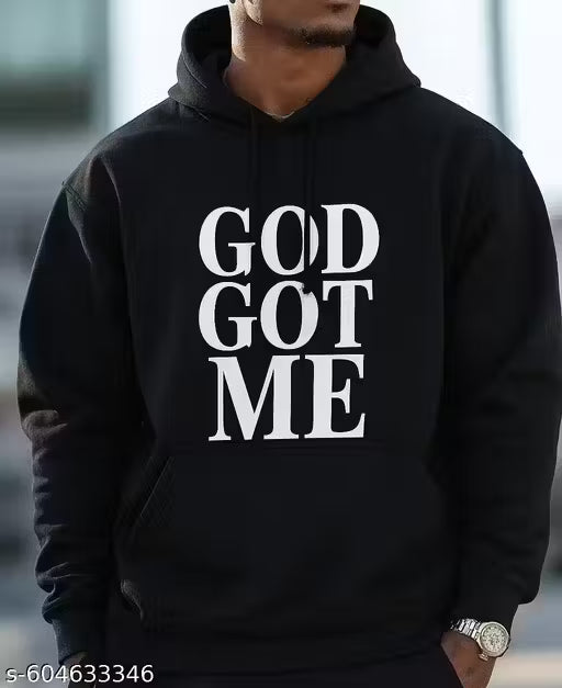 Black hoodie with 'GOD GOT ME' text worn by a person, blurred background