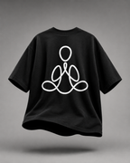 A black short-sleeve t-shirt with a white minimalist line-art graphic of a meditating figure on the front, shown floating against a neutral gray background.