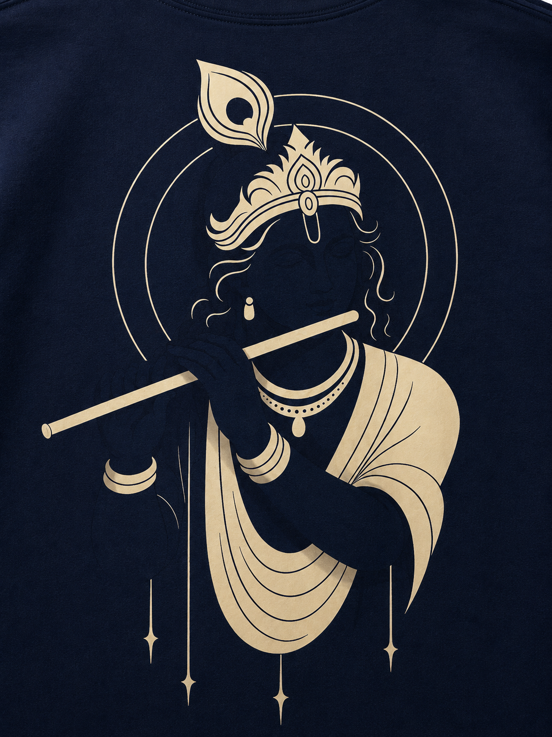 A close-up of a navy blue t-shirt featuring a large graphic print of Lord Krishna in cream-colored lines, holding a flute and wearing a crown and draped clothing.
