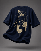 A navy blue short-sleeve t-shirt shown from the back, featuring a large gold graphic of Lord Krishna holding a flute. The t-shirt is presented in a floating, dynamic pose against a dark gray studio background.